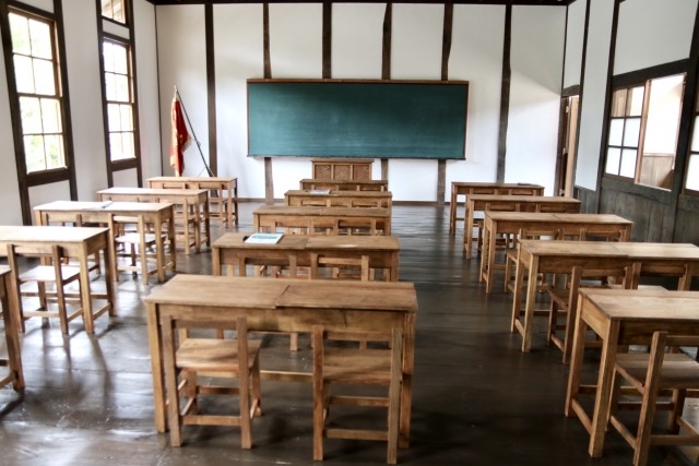 木製の机が並ぶ教室